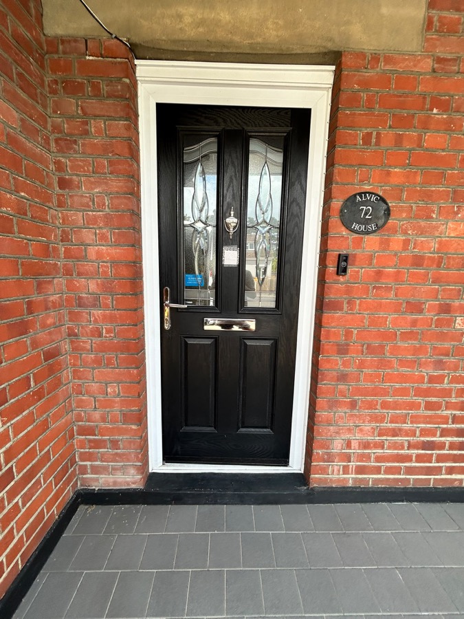 Black composite front door with decorative glazed panels fitted in Essex
