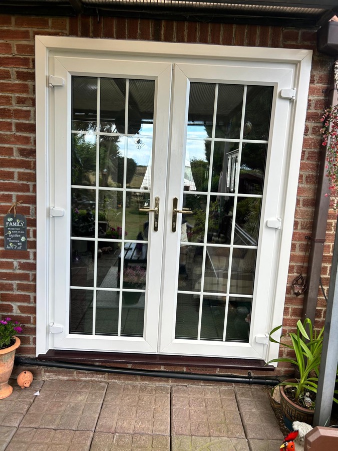 White uPVC French doors with Georgian bar glazing fitted to a brick Essex home